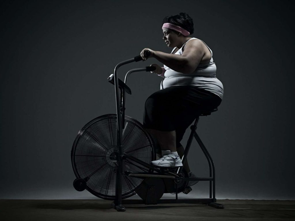 Overweight woman on exercise bike